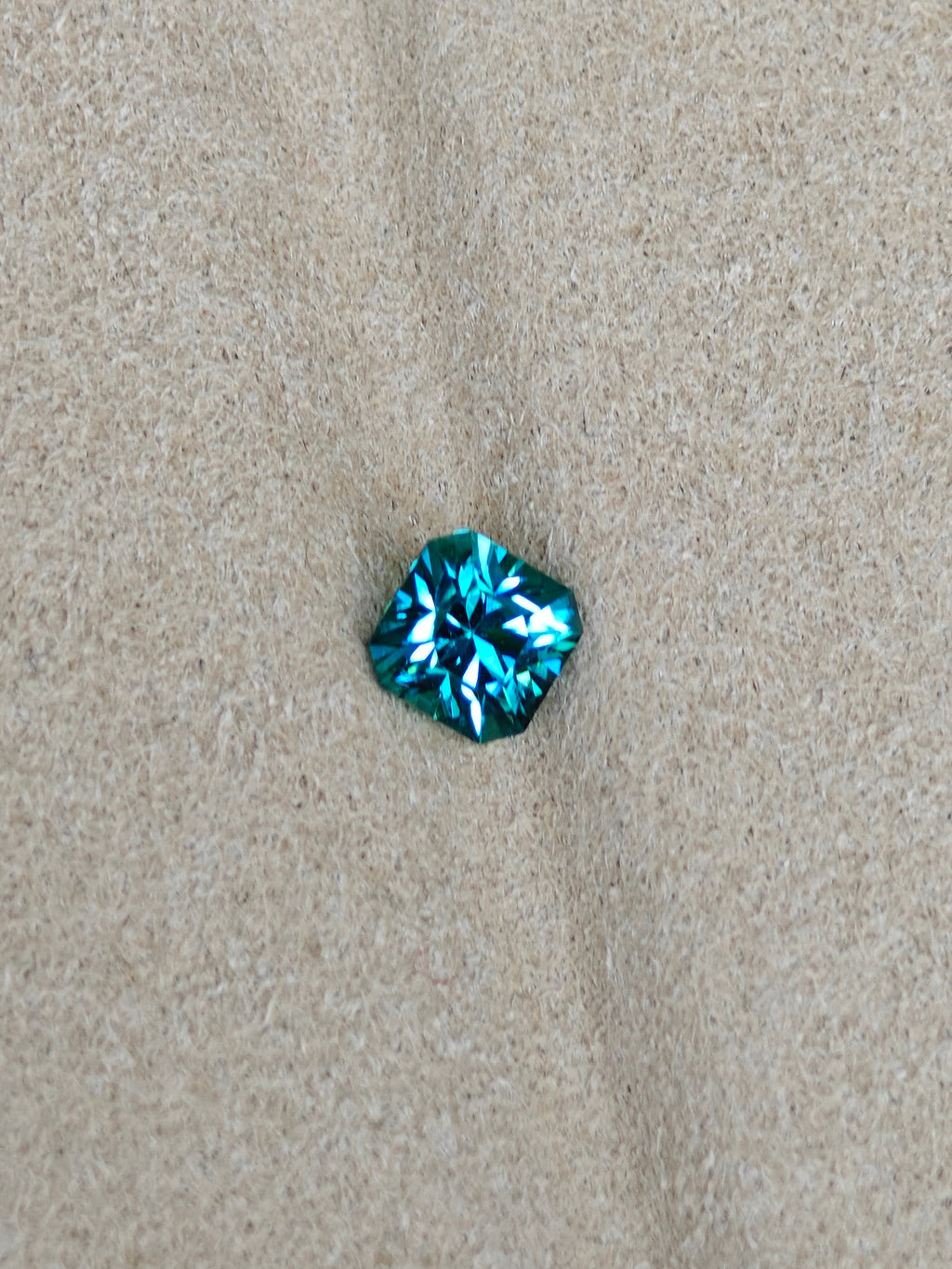 Blue gemstone on a beige fabric background