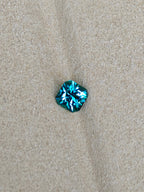 Blue gemstone on a beige fabric background