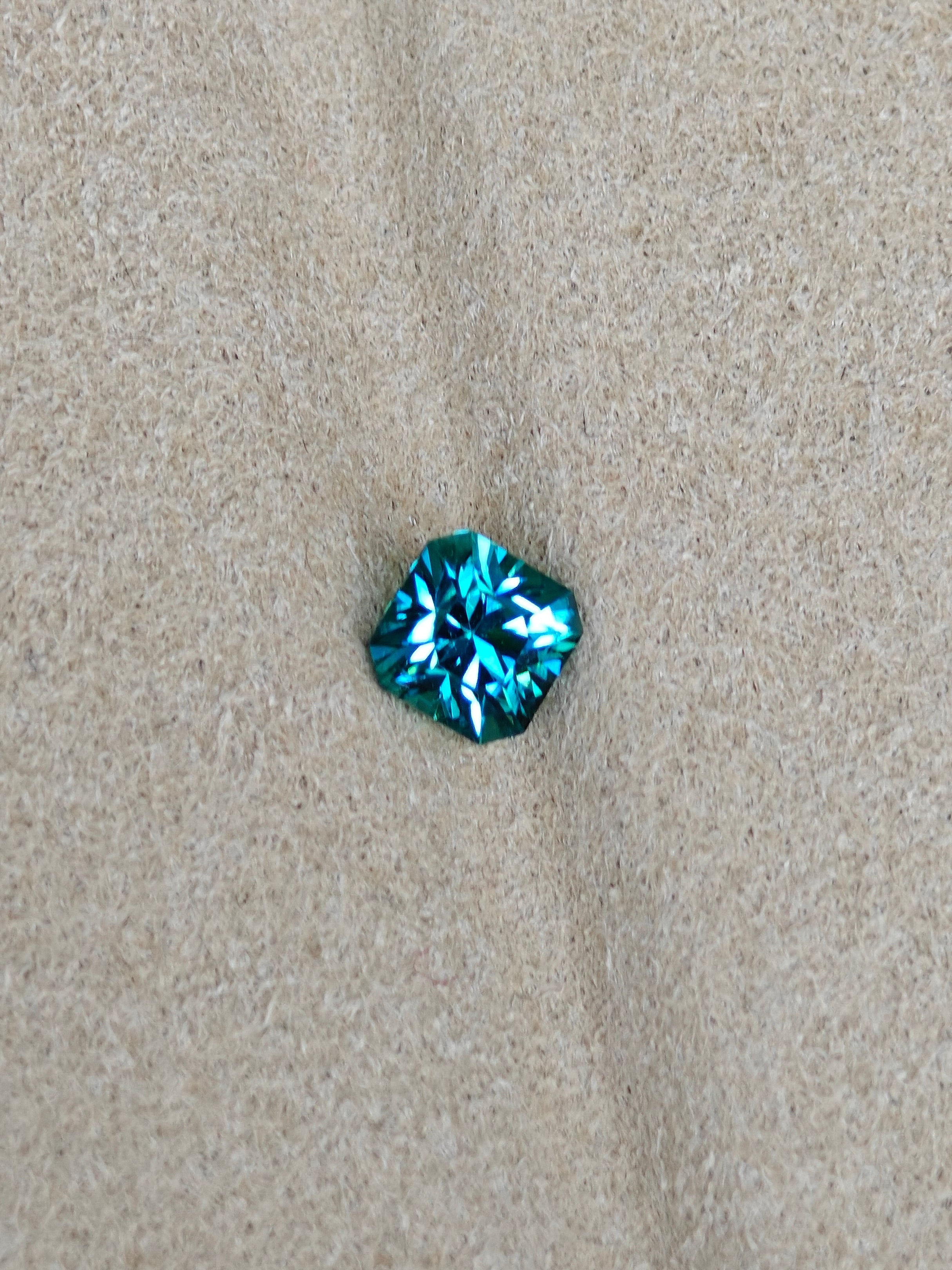 Blue gemstone on a beige fabric background